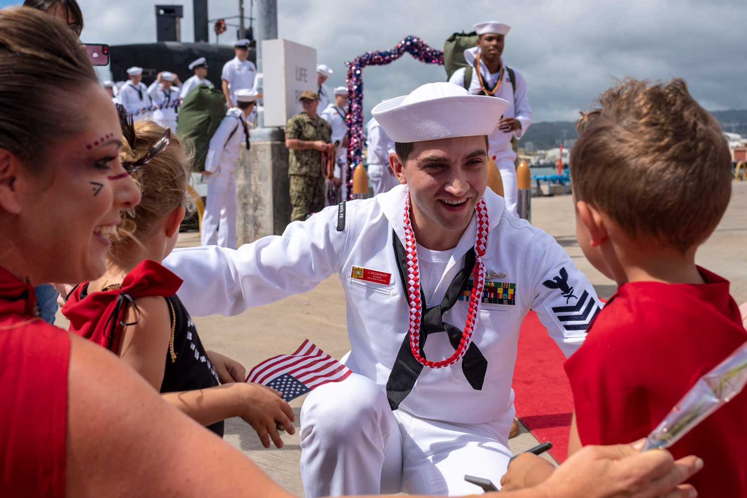 A U.S. Navy Sailor is greeted by his family
