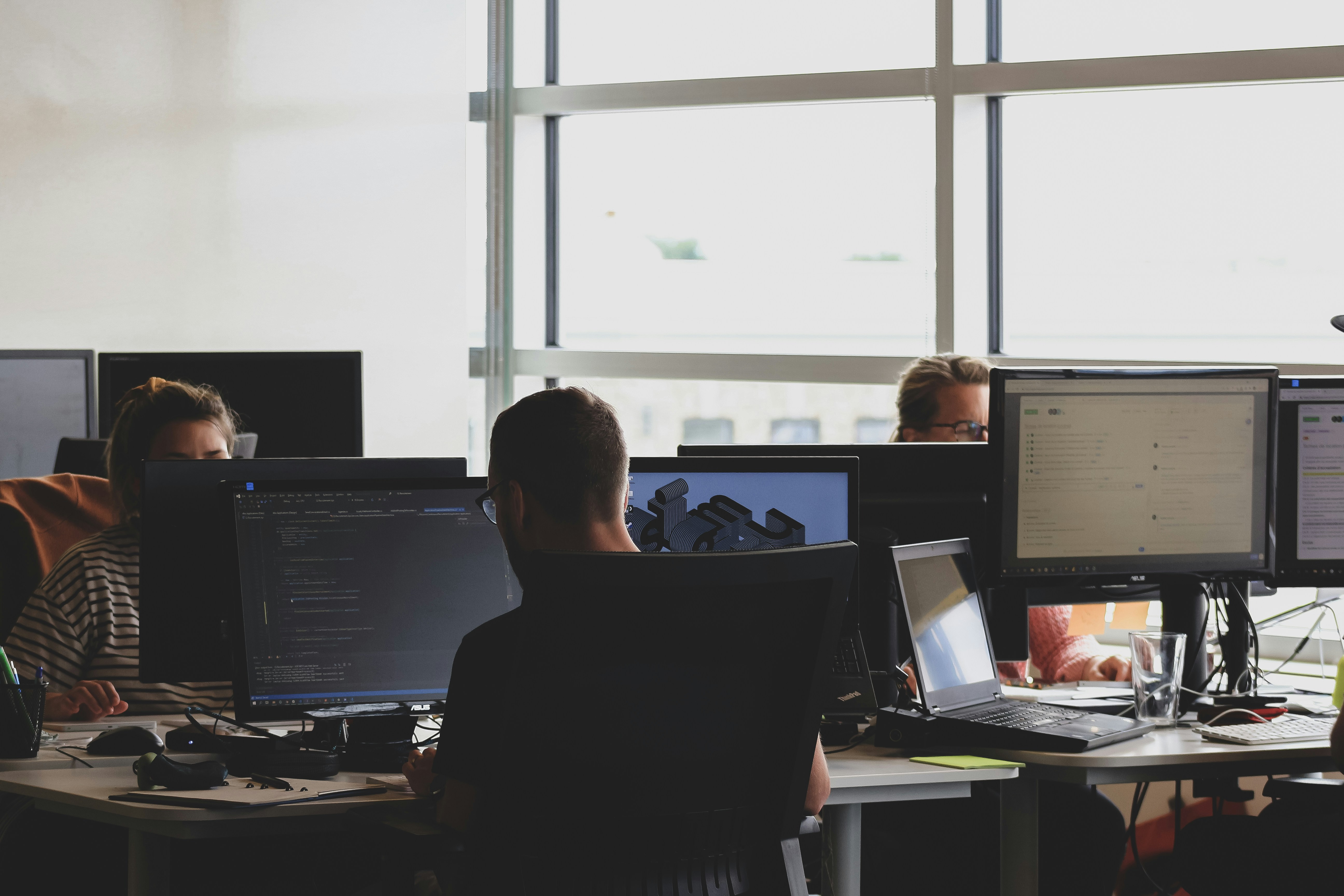 People working in front of computer monitors.